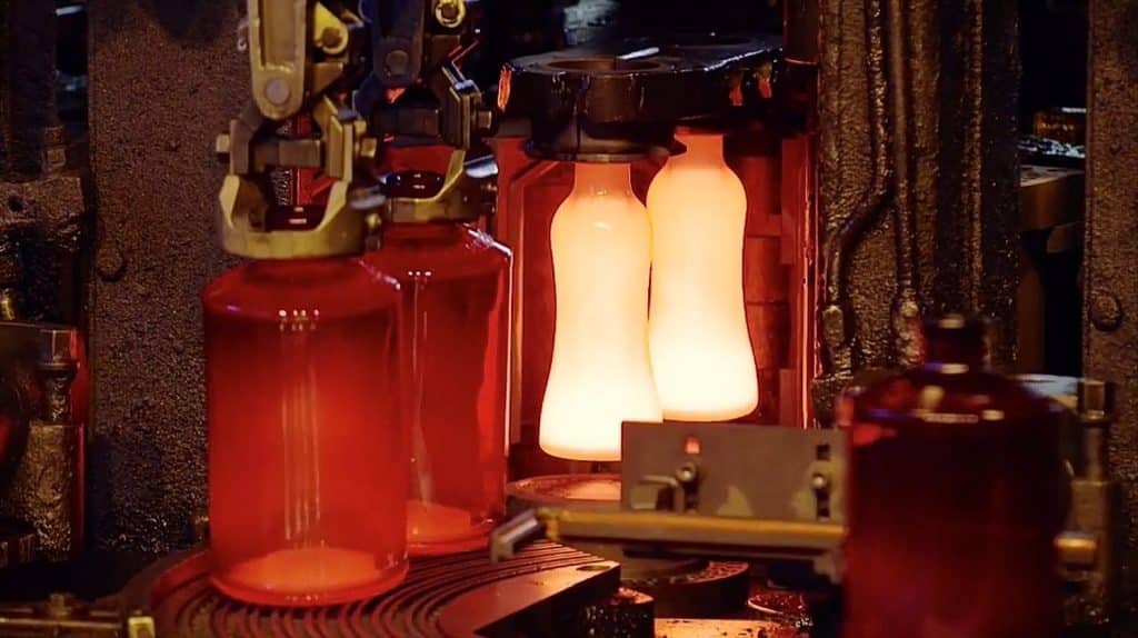 Molten glass gobs dropping into bottle molds