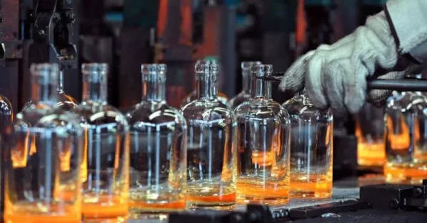 Hot glass bottles coming off the forming machine