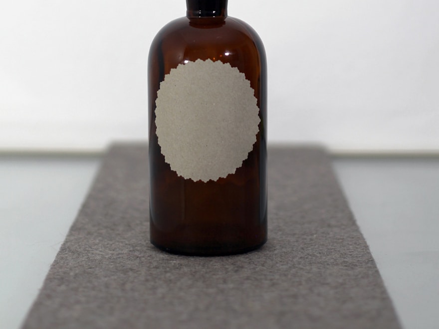 Amber Boston round glass bottle on a soft grey backdrop