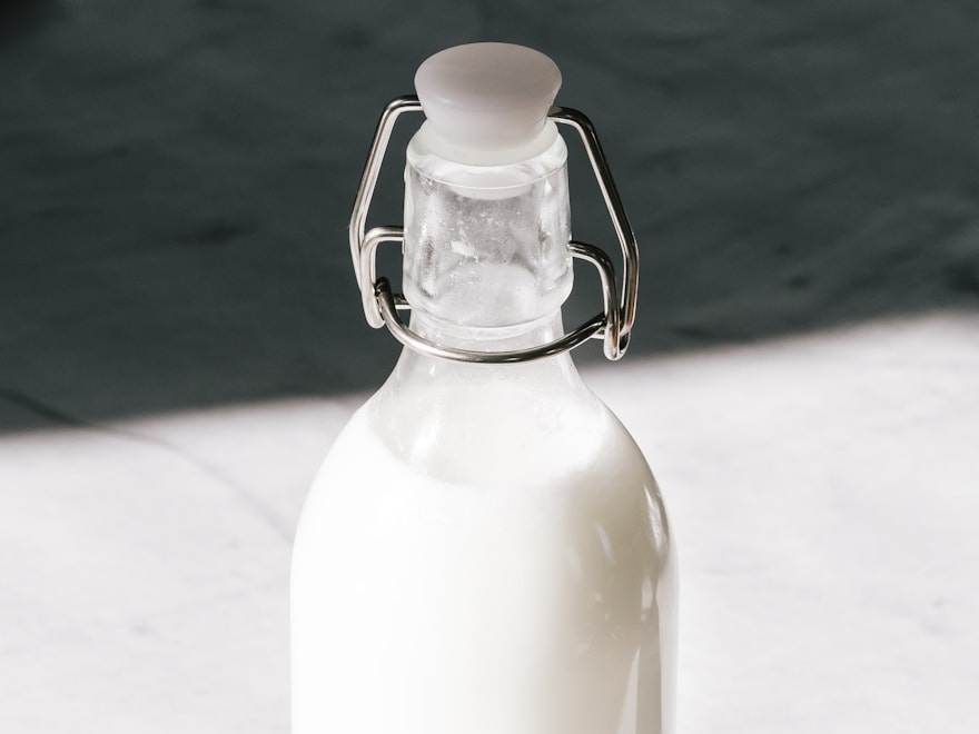 Glass milk bottle with a swing-top closure on a marble surface