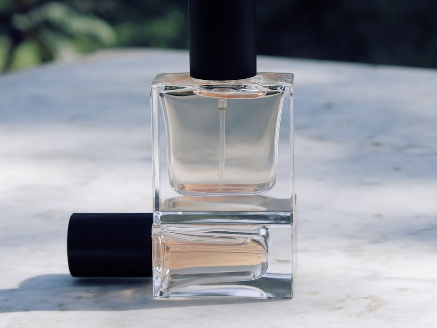 Clear glass perfume bottle with a black crimp spray cap