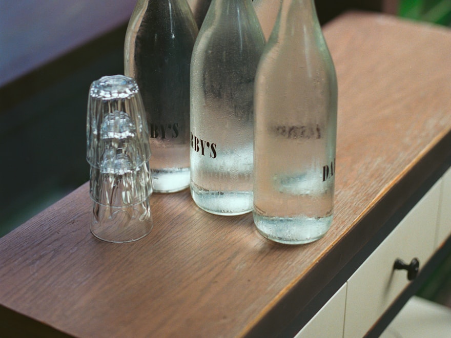 Clear glass swing-top bottles on a wooden kitchen counter