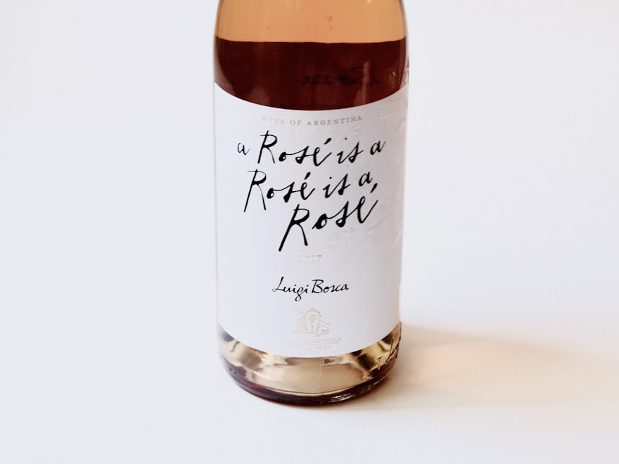 Glass wine bottle with a paper label on a cream surface