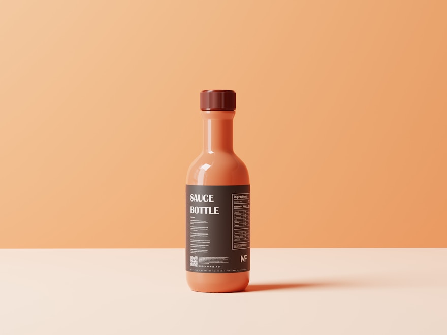 Glass sauce bottle on a warm terracotta backdrop