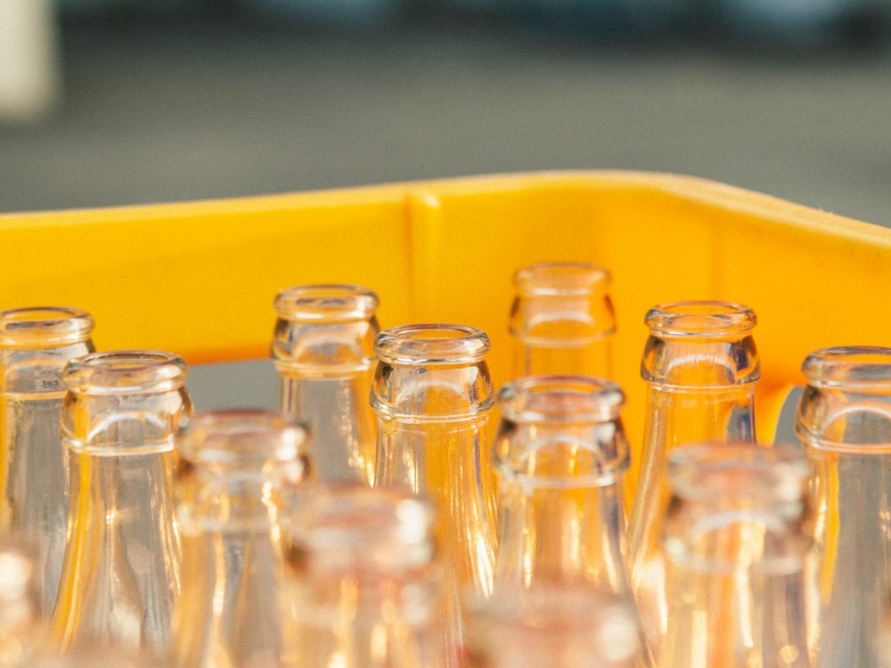 Close-up of empty glass bottle neck finishes in a crate, showing the sealing rings